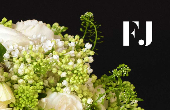 White Fete Jarden logomark on photo of lush white flowers against black background.